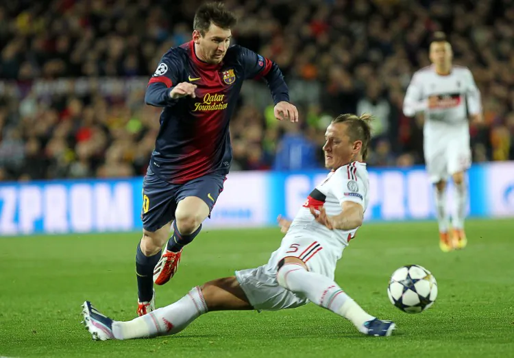 Barcelona’s Lionel Messi moves past AC Milan defender Philippe Mexes in Champions League action in Barcelona on Mar. 12, 2013. (Quique Garcia/AFP/Getty Images)