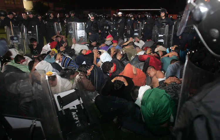 Mexican policemen surround a group of students under arrest after a violent protest following the breakdown of talks with the state government on a syllabus, in Tiripetio, Michoacan State, on Oct.15. A confrontation between policemen and students of three schools of Michoacan State, western Mexico, left 176 people arrested and 10 uniformed men injured. (Enrique Castro/AFP/Getty Images)
