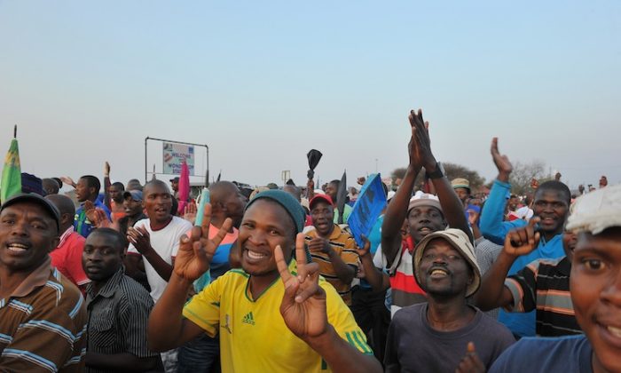 A man flashes the victory sign after striking miners secured a 22-percent pay hike from Lonmin platinum mine in Marikana on Sept. 18. The miners will resume work on Thursday, Sept. 20. (Alexander Joe/AFP/GettyImages)