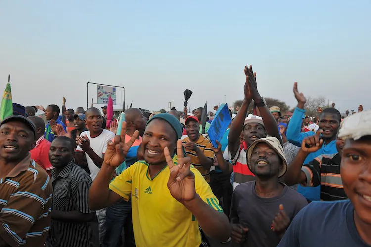 A man flashes the victory sign after striking miners secured a 22-percent pay hike from Lonmin platinum mine in Marikana on Sept. 18. The miners will resume work on Thursday, Sept. 20. (Alexander Joe/AFP/GettyImages)