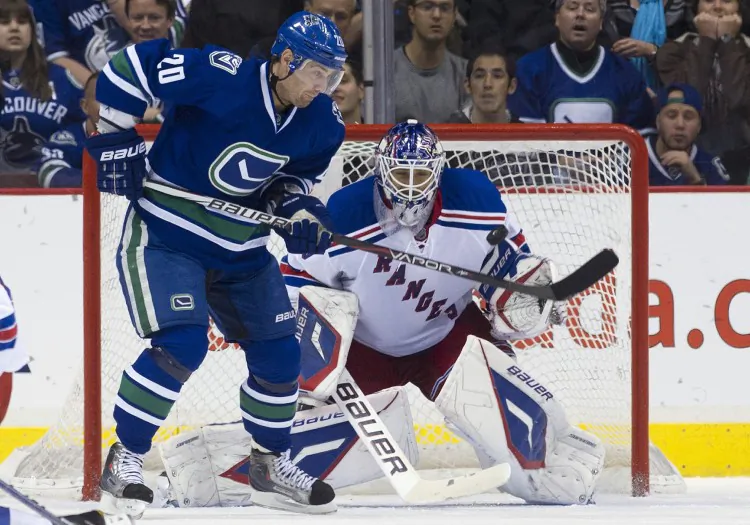 Vancouver’s Chris Higgins tries to score on New York’s Henrik Lundqvist in a game played on Oct. 18, 2011, in Vancouver. The Canucks and Rangers were two of the higher-spending yet more profitable NHL teams last year. (Rich Lam/Getty Images)
