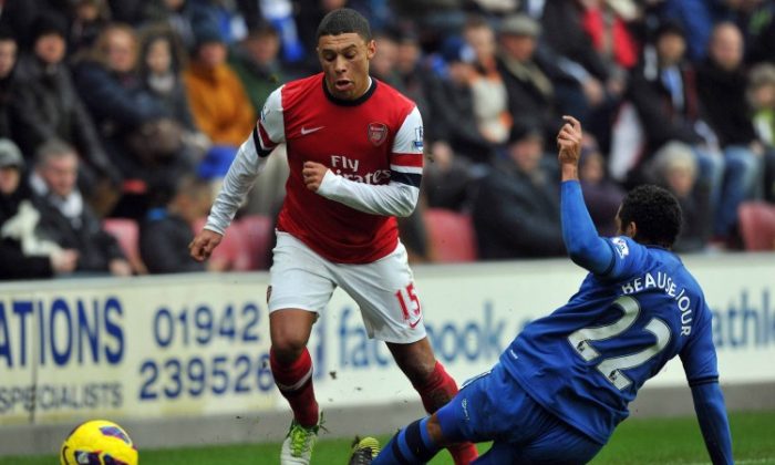 Arsenal’s Alex Oxlade-Chamberlain skips past Wigan defender Jean Beausejour in Barclays Premier League action in Wigan on Saturday, Dec. 22, 2012. (Paul Ellis/AFP/Getty Images)