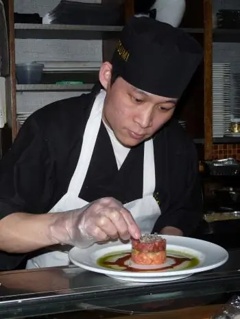 The chef meticulously decorating the salmon and tuna tartar. (Nadia Ghattas/The Epoch Times)