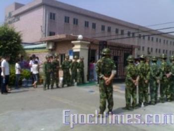 Police guard the gates at the factory. (The Epoch Times) Police guard the gates at the factory. (The Epoch Times)