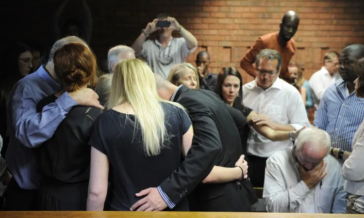 The father and other family members of Oscar Pistorius, South African Olympic sprinter who is set to be charged with murdering Reeva Steenkamp, comfort each other on February 19, 2013 after the athlete's bail hearing was adjourned at the Magistrate Court in Pretoria. (Stephane De Sakutin/AFP/Getty Images)