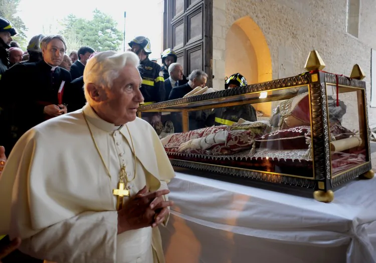 Pope Benedict XVI (L) stands near the relic of Pope Celestine V after covering it with a stole during his papal visit at St. Maria of Collemaggio on April 6, 2009. Celestine V is the only pope besides Pope Benedict XVI known to have resigned freely of his own will. (Osservatore Romano/AFP/Getty Images)