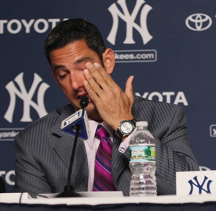 Jorge Posada wipes a tear from his eye during an emotional announcement of his retirement from baseball. (Mike Stobe/Getty Images)