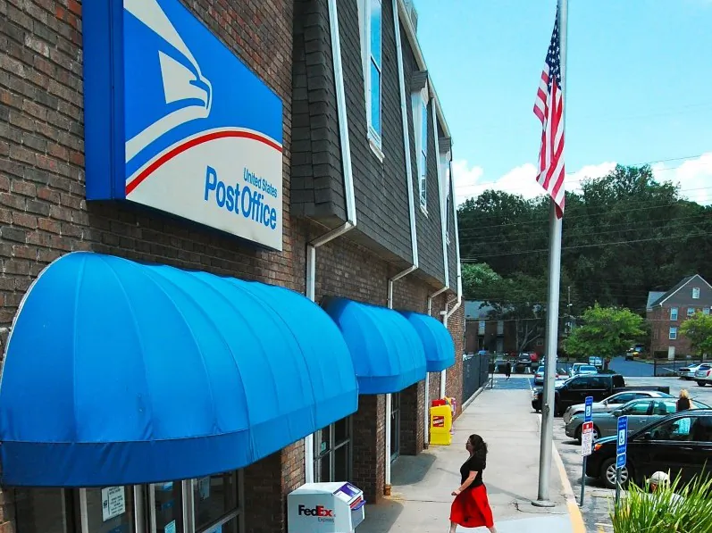 A patron enters a post office in Williamsburg Village Shopping Center in Atlanta on July 30. (Mary Silver/The Epoch Times)