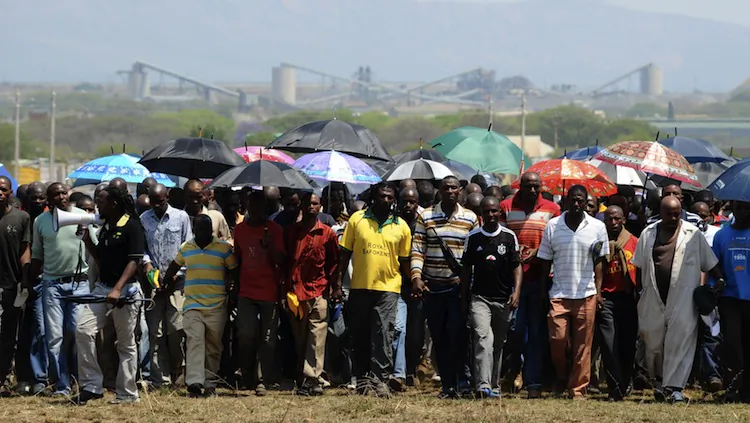 Hundreds of the 12,000 miners sacked by the world's largest platinum producer in South Africa are on their way to a hill Oct. 6, where they will mourn a colleague who was killed in clashes with police in Bleskop on Oct. 4. (Alexander Joe/AFP/GettyImages)