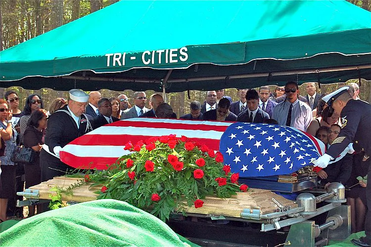 Sailors cover Dr. Lanier Phillips's casket with a flag in his home town of Lithonia, Ga., on March 19. (Mary Silver/The Epoch Times)