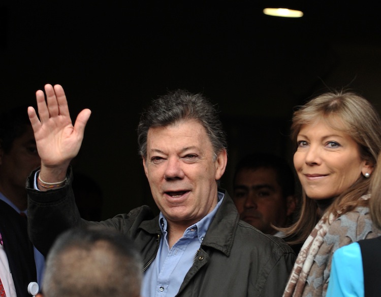 Colombian President Juan Manuel Santos accompanied by his wife Maria Clemencia Rodriguez de Santos, waves to the press as he enters the Santa Fe Foundation Clinic in Bogota on Oct. 3, to undergo prostate cancer surgery. (Guillermo Legaria/AFP/GettyImages)