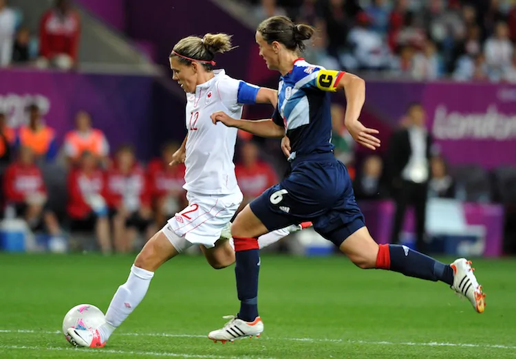 Canada’s Christine Sinclair (L) gets past Great Britain’s Casey Stoney in Olympic women’s soccer quarterfinal action on Friday. (Paul Ellis/AFP/GettyImages)