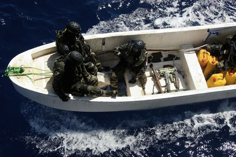French soldiers sit alongside a cache of weapons seized from suspected Somali pirates as they arrive by launch at the French warship 'Le Nivose' on May 3, 2009, as part of EU's Atalante anti-piracy naval mission. (Pierre Verdy/AFP/Getty Images)