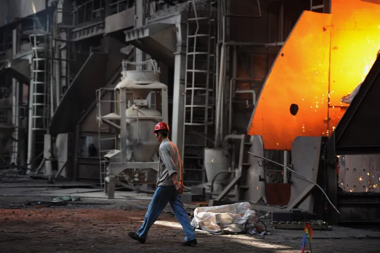 A worker walking past a giant cauldron at a steel mill in Anhui province on June 25, 2011. (STR/AFP/Getty Images)