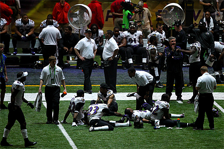 Baltimore Ravens players stretch during a power outage that caused a 34-minute delay during the third quarter of Super Bowl XLVII against the San Francisco 49ers at the Mercedes-Benz Superdome on February 3 in New Orleans, Louisiana. (Dilip Vishwanat/Getty Images)