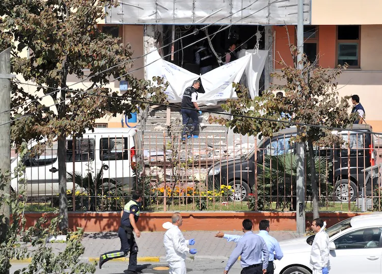 Police forensic officers inspect the site in front of the Sultangazi district police station following an attack on Sept. 11, in Istanbul. At least one police officer died and five people were severely wounded on Tuesday. (Bulent Kilic/AFP/GettyImages)