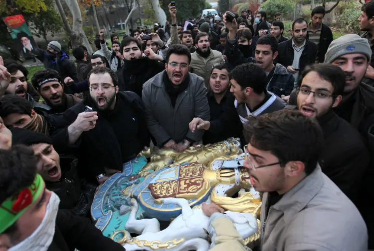 Protesters carry the British royal coat of arms after breaking in to the U.K. Embassy in the Iranian capital on Nov. 29, in Tehran. (FarsNews/Getty Images)