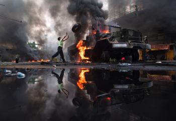 An anti-government protester 'Red Shirt' throws a tire toward a burned truck as the violence in central Bangkok continues on May 16, in Bangkok, Thailand. (Athit Perawongmetha/Getty Images) An anti-government protester 'Red Shirt' throws a tire toward a burned truck as the violence in central Bangkok continues on May 16, in Bangkok, Thailand. (Athit Perawongmetha/Getty Images)