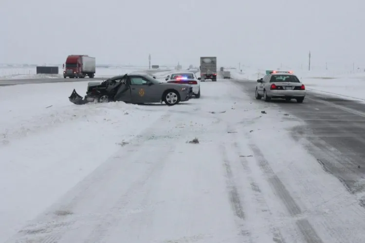 A trooper on I-70 in northwest Kansas stops to help a car stuck in the snow, on the side of the road. In the meantime, his car gets struck by other cars driving by. (Kansas City Highway Patrol)