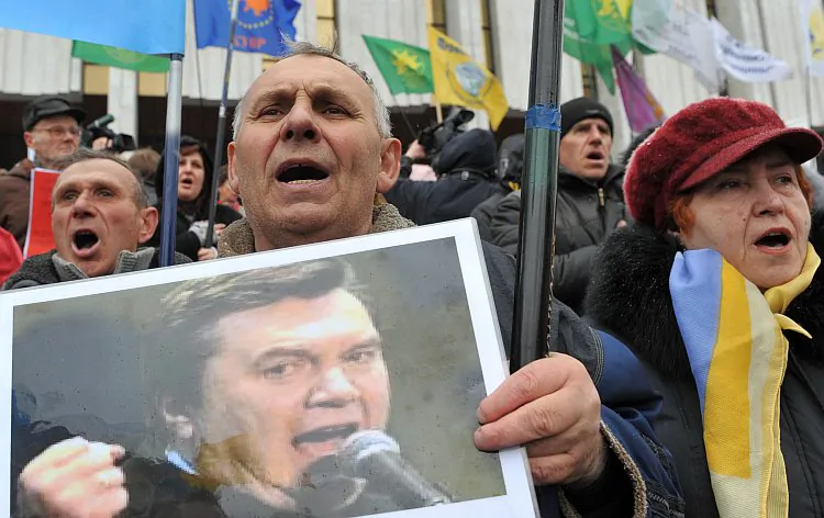 People hold placards against President Viktor Yanukovych during a protest rally of small businessmen in Kyiv on March 25, 2011. Business owners say corruption by tax collectors and other officials is making it impossible to do business. (Sergei Subinsky/AFP/Getty Images)
