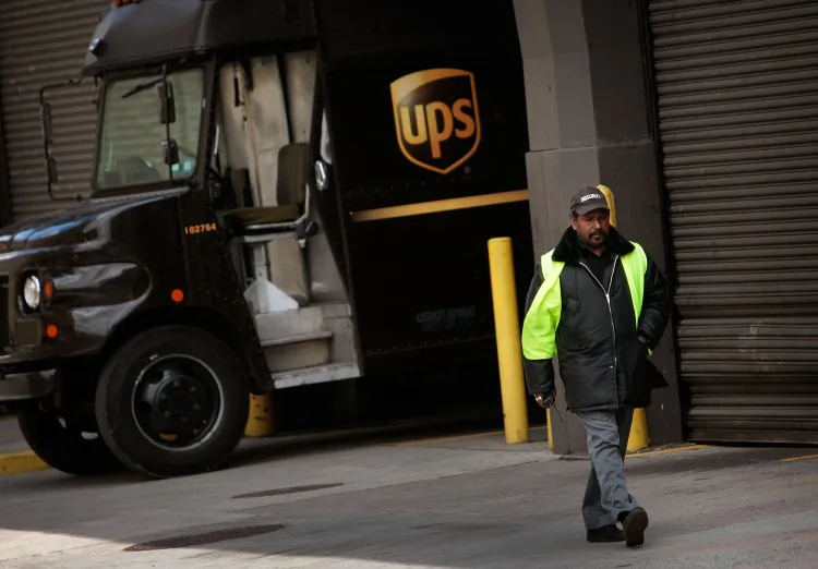 A UPS worker walks by a truck parked at a package depot in New York in this file photo. (Chris Hondros/Getty Images)