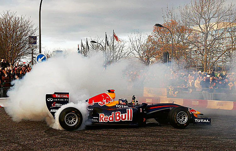 Sebastian Vettel does donuts in the championship-winning RB7 for the crowd at Milton Keynes. (Richard Heathcote/Getty Images for Red Bull)