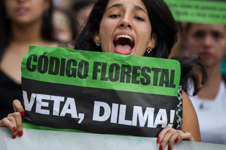 A woman raises a banner demanding Brazilian President Dilma Rousseff veto a forest code approved by the congress last month, in Sao Paulo, Brazil on May 5. (Yasuyoshi Chiba/AFP/GettyImages)