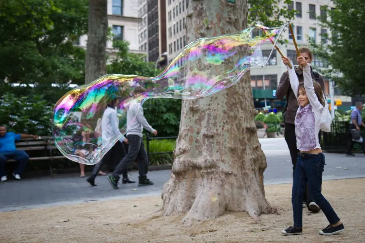 FEELING BUBBLY: Children make large bubbles in Madison Square Park, Manhattan on June 13. (Benjamin Chasteen/The Epoch Times)
