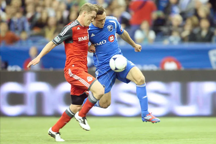Montreal’s Andrew Wenger (R) gets past Toronto FC’s Ty Harden in MLS action on Saturday. (Richard Wolowicz/Getty Images)