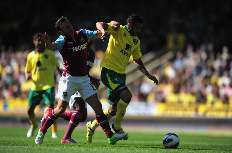 West Ham’s Mark Noble (L) and Norwich’s Robert Snodgrass battle for possession in Saturday’s early English Premier League action. (Jamie McDonald/Getty Images)