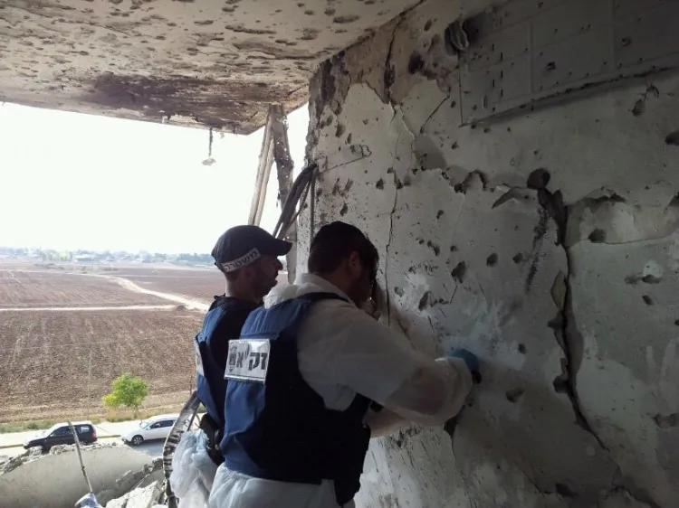 Volunteers for emergency response workers Zaka working inside a house in Kiryat Malachi where three people were killed Wednesday by rockets from Gaza. (Courtesy David Rose)