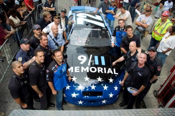 REMEMBER THIS: Both wearing 9/11 memorial shirts, NASCAR driver Benny Gordon (L Front), 9/11 Memorial President Joe Daniel (R Middle), and other launch the 9/11 race car near Ground Zero. (Aloysio Santos/The Epoch Times)