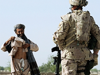 A Canadian soldier with the NATO-led International Security Assistance Force (ISAF) stops an Afghan passer-by during a patrol in Panjwayi district, some 30 kms west of Kandahar province earlier this year. The deaths of two children have brought Canadian s (Shah Marai/AFP/Getty Images)