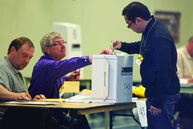 A voter casts his ballot in the May federal election at a polling station in Calgary. Elections Alberta recently expressed concern when they were unable to reach over 300,000 eligible voters during a late-summer door-to-door enumeration. (Geoff Robins/AFP/Getty Images)
