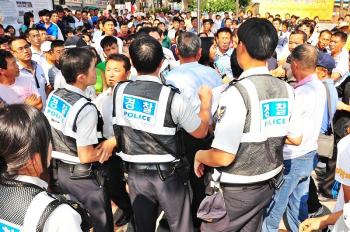 The thugs who usually are afraid of police behaved aggressively in the presence of many policemen. (Jin Guohuan/The Epoch Times) The thugs who usually are afraid of police behaved aggressively in the presence of many policemen. (Jin Guohuan/The Epoch Times)