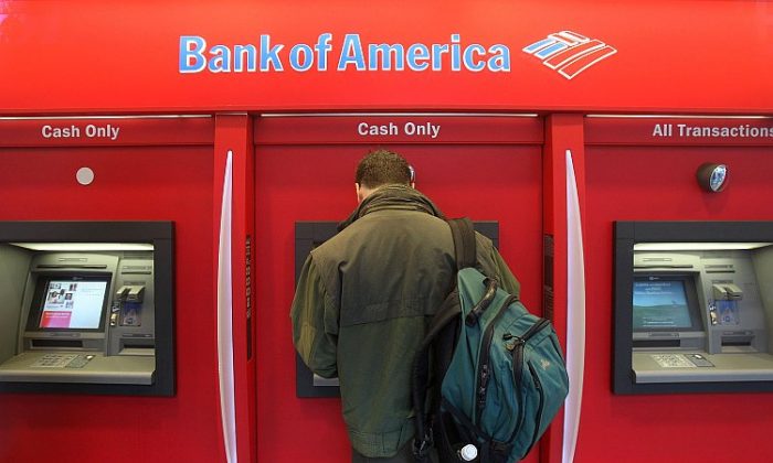 This 2008 file photo shows a man standing in a Bank of America ATM branch in New York City. B of A has agreed to pay $335 million to settle allegations that its Countrywide Financial Corp. unit engaged in discrimination against qualified minority loan applicants from 2004 to 2008. (Mario Tama/Getty Images)