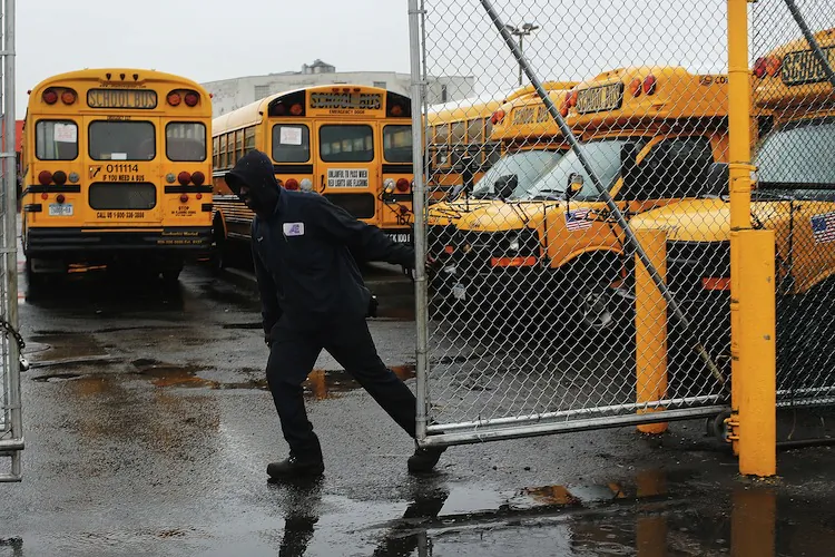 A worker at with Atlantic Express closes the gate for school buses in New York City on Jan. 16, 2013, after drivers started to strike. (Spencer Platt/Getty Images)