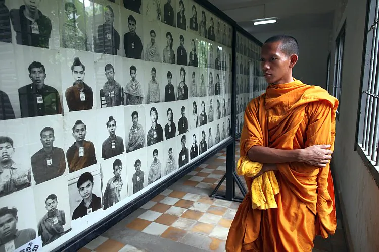 A Cambodian monk looks at photos of victims of the Khmer Rouge regime on display at the Toul Sleng Genocide museum in Phnom Penh Province, Cambodia. (Paula Bronstein/ Getty Images)