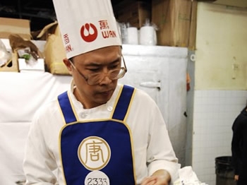 Chen Yongming, gold prize winner of 2008 NTDTV Chinese International Culinary competion, focuses on his food. (Dai Bing/The Epoch Times)