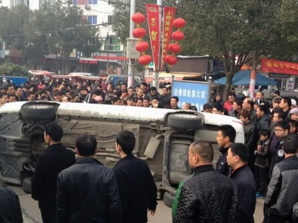 On Feb. 24, urban enforcers beat a motorbike rider near Datian Triangle Park in Linhai City, Zhejiang. Over 1,000 onlookers were angered by the incident, and some overturned the police car. (Weibo.com)