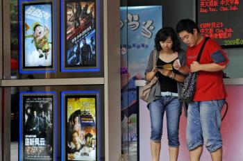 A man and a woman check their movie tickets in Shanghai. Movie ticket prices have skyrocketed in China, and now a ticket costs as much as 5 percent of per capita monthly income. (Philippe Lopez/AFP/Getty Images)