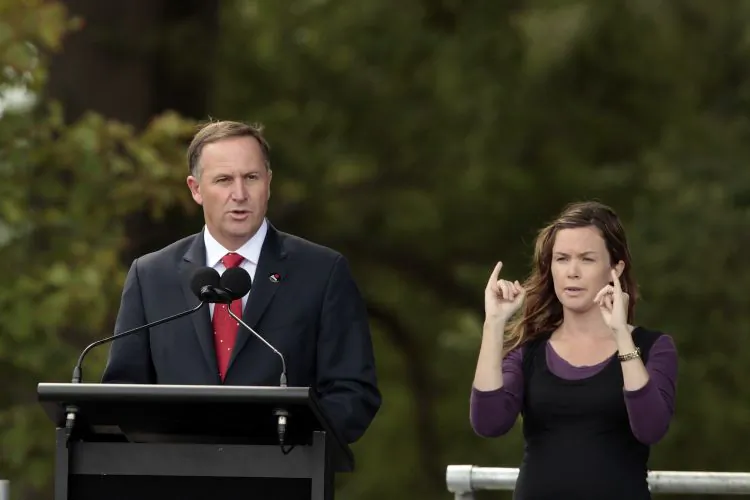 New Zealand Prime Minister John Key, with interpreter, speaks ahead of the one year Christchurch earthquake anniversary on Feb. 22.
