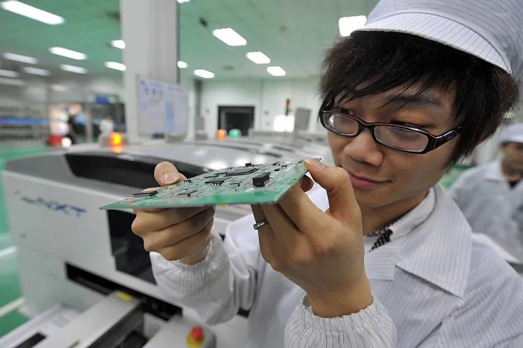 A Chinese worker checks the circuit boards at a factory in Mianyang, southwest China's Sichuan province. A recent study found that a U.S. military chip manufactured in China—widely used in systems for weapons, nuclear power plants, and public transport—contains a built-in backdoor. (STR/AFP/GettyImages)