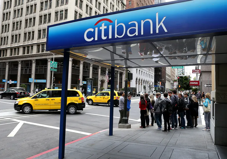 Pedestrians walk by a Citibank branch office on July 16 in San Francisco, Calif. Citigroup has agreed to pay $590 million to settle a class-action shareholder lawsuit claiming that the bank failed to disclose exposure to subprime and other risky assets leading up to the financial crisis. (Justin Sullivan/Getty Images)
