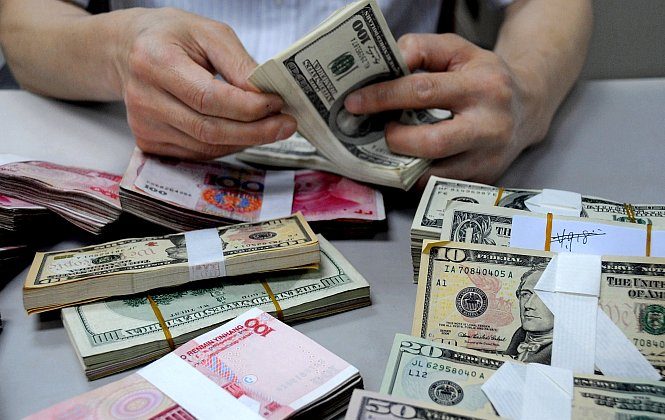 A staff member counts money at a branch of the Bank of China in Lianyungang, Jiangsu Province, China, in this file photo. Because of the currency wars going on between countries like the United States and China, there is a lot of pressure to get away from the dollar as the world's reserve currency, but the Chinese yuan is very far from becoming the world’s new reserve currency. (ChinaFotoPress/Getty Images)