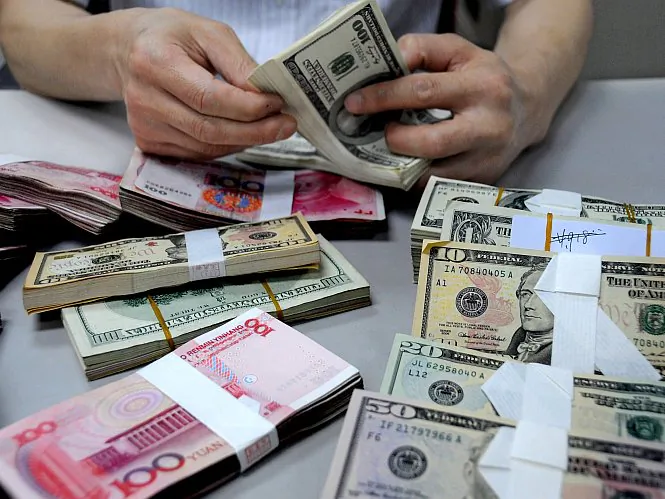 A staff member counts money at a branch of the Bank of China in Lianyungang, Jiangsu Province, China, in this file photo. Because of the currency wars going on between countries like the United States and China, there is a lot of pressure to get away from the dollar as the world's reserve currency, but the Chinese yuan is very far from becoming the world’s new reserve currency. (ChinaFotoPress/Getty Images)