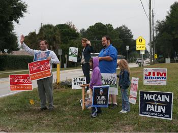 Activists wave signs at incoming voters outside District 332. (James Fish/Epoch Times Staff) Activists wave signs at incoming voters outside District 332. (James Fish/Epoch Times Staff)
