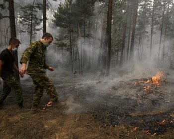 Russian soldiers kick dirt on a forest fire some 130 kilometers from Moscow in Beloomut on August 1. Firefighters fought an uphill battle the fires that have already killed 30 people, destroyed thousands of homes and mobilized hundreds of thousands of emergency workers. (Artyom Korotayev/Getty Images )