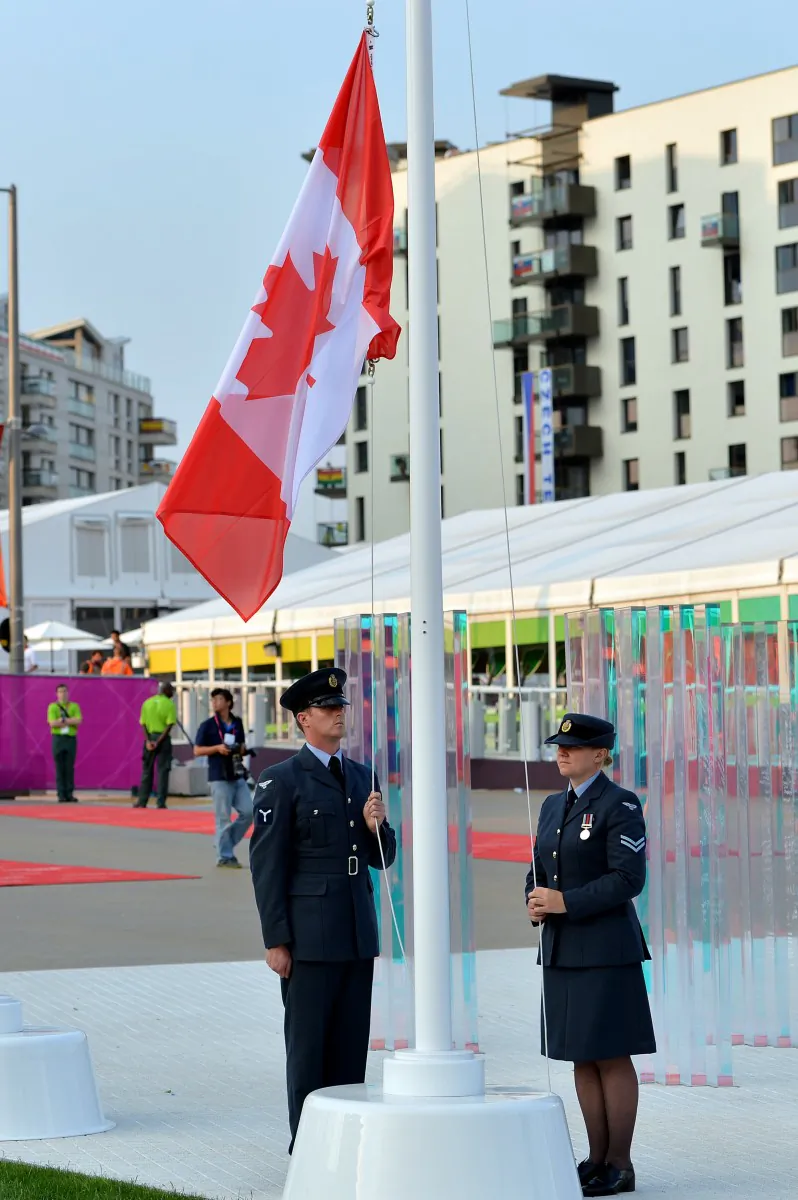 Military personnel hoist the national flag of Canada during the flag-raising ceremony at the Olympic Village in London, England, on July 25, 2012, two days before the start of the London 2012 Olympic Games. (Saeed Khan/AFP/Getty Images)