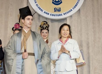 Designer Cheng Minghua (R) stands with his model in the winning piece of the competition. The outfit is in the style of the Ming Dynasty. (Edward Dai/The Epoch Times)